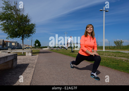 Active woman stretching outdoors Stock Photo
