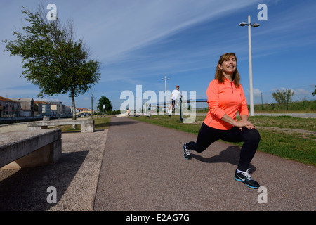 Active woman stretching outdoors Stock Photo