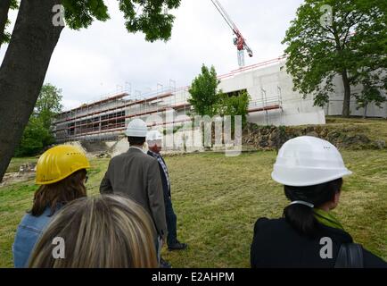 Kassel, Germany. 17th June, 2014. ATTENTION - EMBARGO CONDITION - 18 JUNE 2014 - 15:00 AM - People stand in front of the construction site of the 'Grimmwelt' ('Grimm World') in Kassel, Germany, 17 June 2014. The house on the life and work of the collectors of fairy tales and linguists Jacob and Wilhelm Grimm is scheduled to be opened in mid 2015. Photo: Uwe Zucchi/dpa/Alamy Live News Stock Photo
