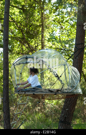 France, Morbihan, Ploemel, Domaine de Dihan tourist accomodation, woman in a suspended bubble tent Stock Photo