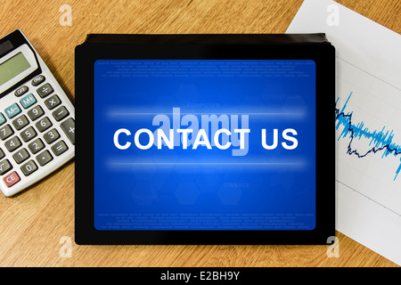 contact us word on digital tablet with calculator and financial graph Stock Photo