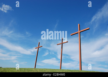 Three empty crosses on a hillside Stock Photo