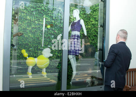 Wimbledon London UK. 18th June 2014. A man window dressing next to a poodle dressed in tennis balls inside the Wimbledon Tennis shop Credit:  amer ghazzal/Alamy Live News Stock Photo