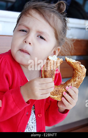 little girl eats bagel Stock Photo