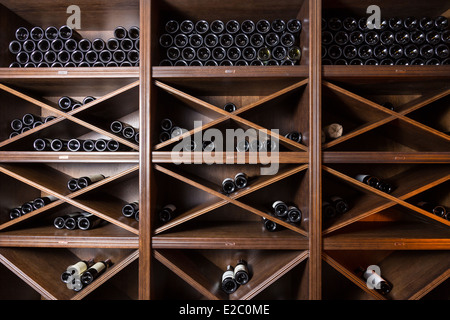 Wine cellar with bottles on wooden shelves Stock Photo