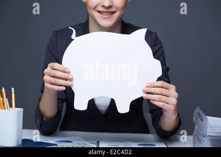Hands of businesswoman holding paper piggy Stock Photo