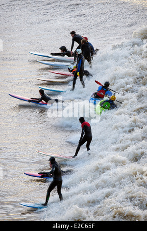 Surfers and canoeists riding the Severn Bore at Newnham-on-Severn, Gloucestershire UK 2014 Stock Photo