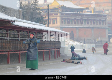 China, Qinghai, Amdo, Xining surroundings, Kumbum monastery (Ta'er Si), Devotees prostrating on icy ground around monastery Stock Photo