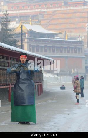 China, Qinghai, Amdo, Xining surroundings, Kumbum monastery (Ta'er Si), Devotees prostrating on icy ground around monastery Stock Photo