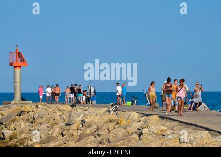 France, Herault, Valras Plage, walkers taking the sun late in the afternoon on the pier Stock Photo