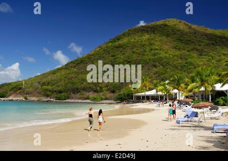 France Guadeloupe Saint Martin anse Marcel young women walking along the shoreline towards the mountain Stock Photo