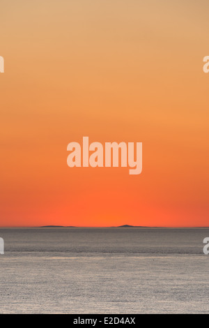 Amazing sunset over Cadigan Bay silhouettes the Llŷn Peninsula in an orange glow. Stock Photo