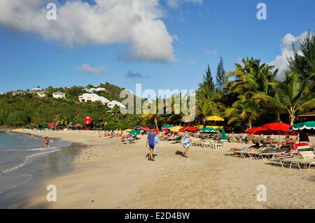 France Guadeloupe Saint Martin anse fathers or Friar's Bay couple walking on the beach toward sunbeds Stock Photo