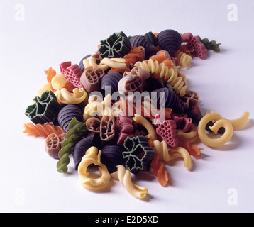 Specialty pastas in a pile on a white background forming a horn shape. Squid ink,spinach,wholemeal and tomato pastas included. Stock Photo