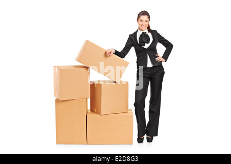Full length portrait of a businesswoman standing next to a pile of boxes Stock Photo