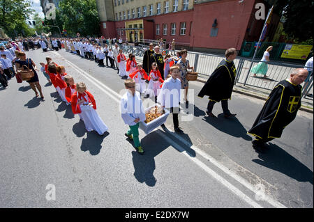 Warsaw, Poland 19th June 2014. The Catholic congregation of eastern side of Warsaw, the capital city of Poland, celebrated The Feast of Corpus Christi on Thursday, 60 days after Easter. The procession at the Saint Florian Cathedral attracted hundreds of people, in particular local firefighters as Saint Florian is considered a patron of firemen. Children throw petals before the priest carrying the  monstrance. Credit:  Henryk Kotowski/Alamy Live News Stock Photo