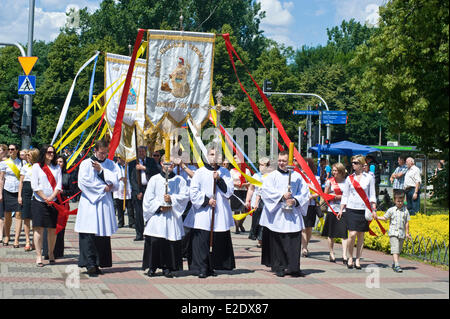 Warsaw, Poland 19th June 2014. The Catholic congregation of eastern side of Warsaw, the capital city of Poland, celebrated The Feast of Corpus Christi on Thursday, 60 days after Easter. The procession at the Saint Florian Cathedral attracted hundreds of people, in particular local firefighters as Saint Florian is considered a patron of firemen. Children throw petals before the priest carrying the  monstrance. Credit:  Henryk Kotowski/Alamy Live News Stock Photo