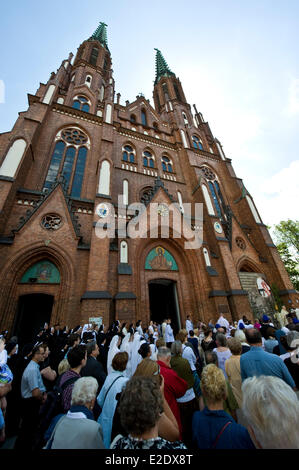 Warsaw, Poland 19th June 2014. The Catholic congregation of eastern side of Warsaw, the capital city of Poland, celebrated The Feast of Corpus Christi on Thursday, 60 days after Easter. The procession at the Saint Florian Cathedral attracted hundreds of people, in particular local firefighters as Saint Florian is considered a patron of firemen. Children throw petals before the priest carrying the  monstrance. Credit:  Henryk Kotowski/Alamy Live News Stock Photo