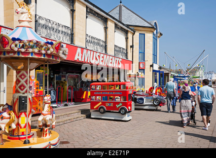 People tourists visitors walking by amusements on the seafront in summer Bridlington East Yorkshire England UK United Kingdom GB Great Britain Stock Photo