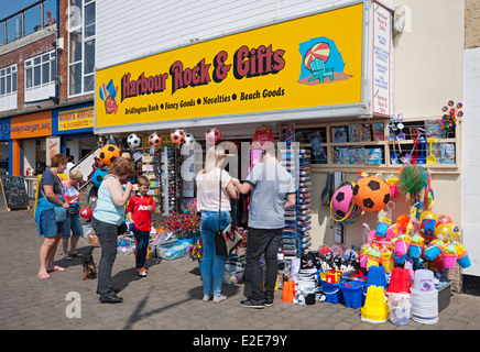 People tourists visitors looking at store Shop Selling Beach Goods on the Seafront in summer Bridlington East Yorkshire England UK United Kingdom Stock Photo