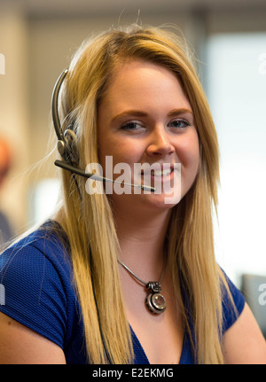 A blonde  female call centre worker at work. Stock Photo