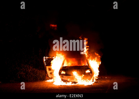 A car on fire at night. Stock Photo
