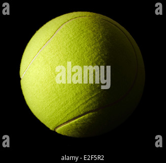 a yellow tennis ball in black back Stock Photo