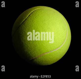 a yellow tennis ball in black back Stock Photo