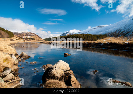 The River Findhorn, flowing along the Findhorn valley through the snow-covered Moadhliath Mountains in Inverness-shire, Scotland Stock Photo
