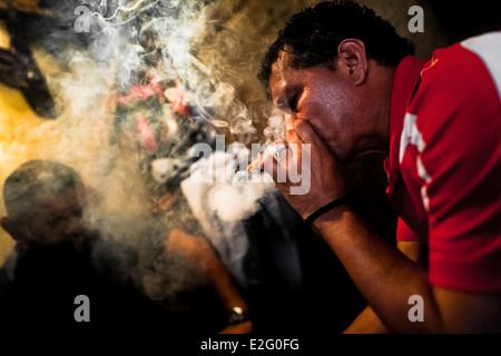 A Salvadorean ‘brujo’ (sorcerer) predicts the future from burn tobacco leaves in a street fortune telling shop in San Salvador. Stock Photo