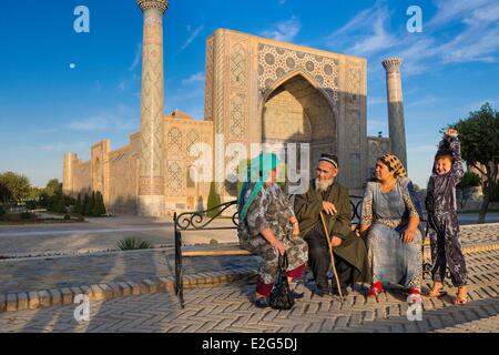 Uzbekistan Silk Road Samarkand listed as World Heritage by UNESCO Registan Square Ferghana valley pilgrims in front of the Stock Photo