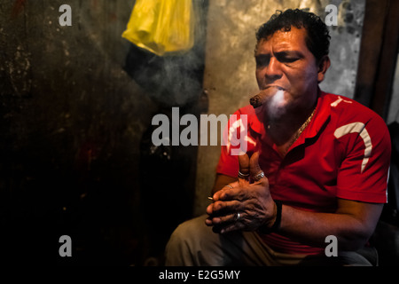 A Salvadorean ‘brujo’ (sorcerer) predicts the future from burn tobacco leaves in a street fortune telling shop in San Salvador. Stock Photo