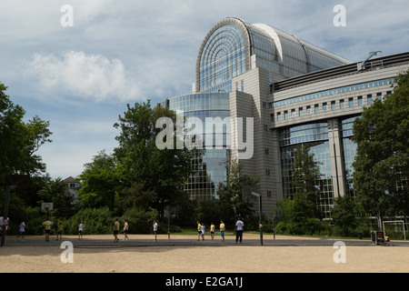 A photograph of some school kids playing football in the shadow of the European Parliament buildings in Brussels. Stock Photo