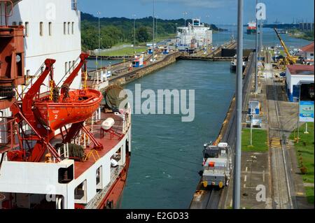 Panama Colon province Panama Canal Gatun locks mechanical mules or electric locomotives guiding a Panamax container ship between lock walls Stock Photo