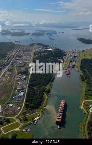 Panama Colon province Panama Canal Panamax cargo passing Gatun locks construction of new locks on left and Gatun Lake in background (aerial view) Stock Photo