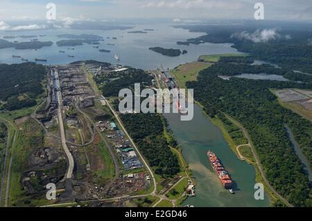 Panama Colon province Panama Canal Panamax cargo passing Gatun locks construction of new locks on left and Gatun Lake in background (aerial view) Stock Photo