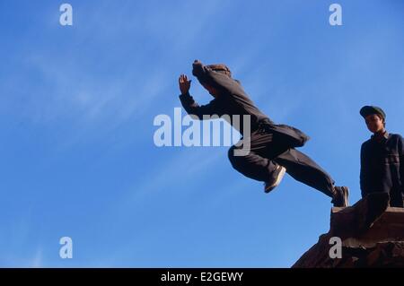 Pakistan Khyber Pakhtunkhwa Kalash valleys Bumburet valley child jump roof to roof of Kalash houses Stock Photo