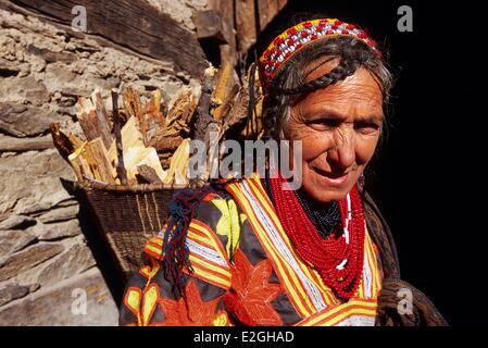 Pakistan Khyber Pakhtunkhwa Kalash valleys Bumburet valley Kalash woman carrying wood in her Kawa traditional conical hood Stock Photo