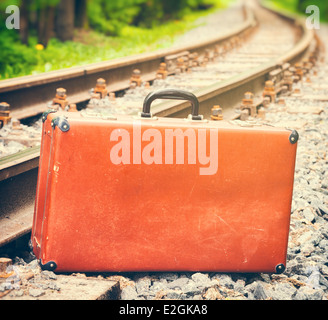 vintage brown suitcase standing beside the railway Stock Photo