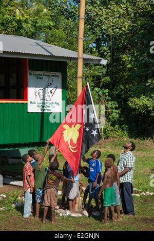 Papua New Guinea New Britain island West New Britain province Talasea district Cap Gloucester area Kilenge village kids and teachers are rising national flag on St Ignacius school Stock Photo