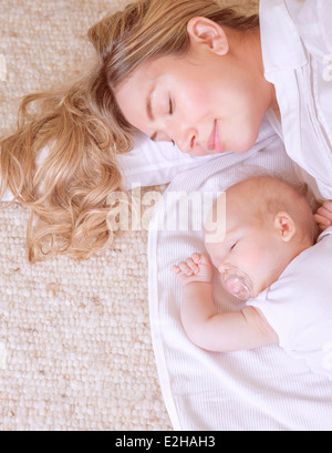 Photo of adorable newborn baby with beautiful young mother resting at home, bedtime, happy loving family, new life concept Stock Photo