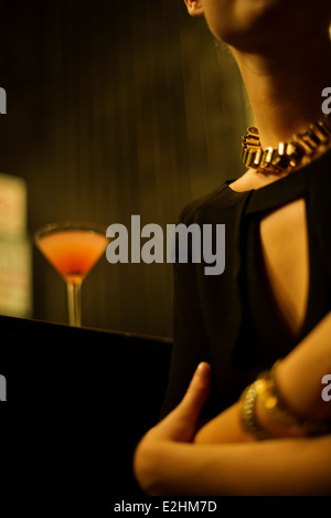 Woman sitting alone at night club bar Stock Photo