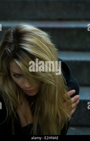 Woman sitting alone on steps Stock Photo