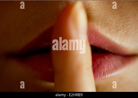 Woman with finger on lips Stock Photo