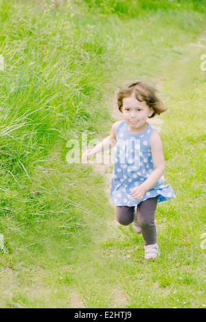 Little girl running on path through countryside Stock Photo