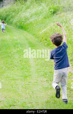 Boy running on country path, rear view Stock Photo