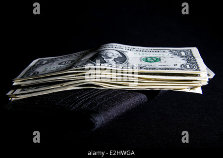 Pile of American one dollar bills on top of a black wallet Stock Photo