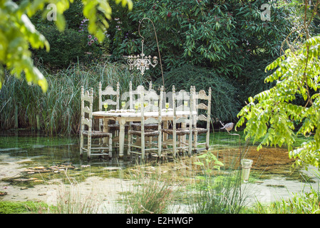 Ornate dining table floating in pond Stock Photo