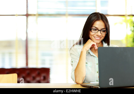 Smiling businesswoman working on the laptop at office Stock Photo