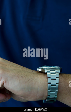 Man wearing wristwatch, checking time Stock Photo